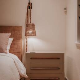 a bedroom with a bed, nightstand, and lamp